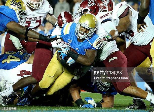 Running back Malcolm Jones of the UCLA Bruins dives across the goal line for a three yard touchdown run in the fourth quarter against the New Mexico...
