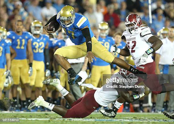 Quarterback Brett Hundley of the UCLA Bruins jumps over a New Mexico State Aggies defender at the Rose Bowl on September 21, 2013 in Pasadena,...