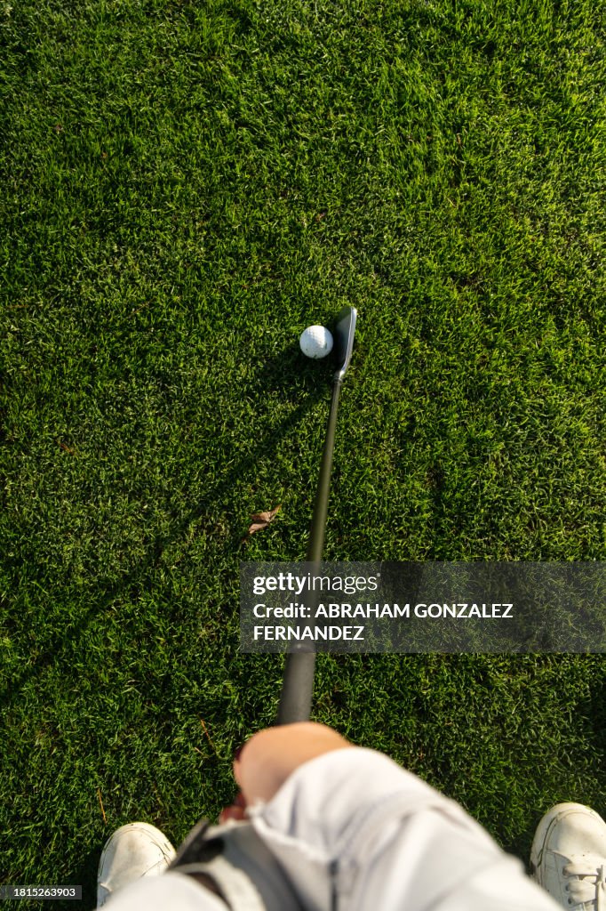 A golfer about to hit a golf ball