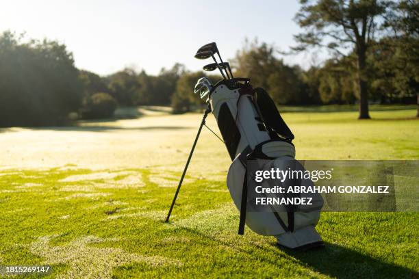 golf bag with golf clubs inside in a green court - golf bag stock pictures, royalty-free photos & images