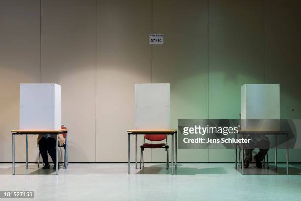 People cast their ballots in German federal elections at a culture center on September 22, 2013 in Halle, Germany. Germany is holding federal...