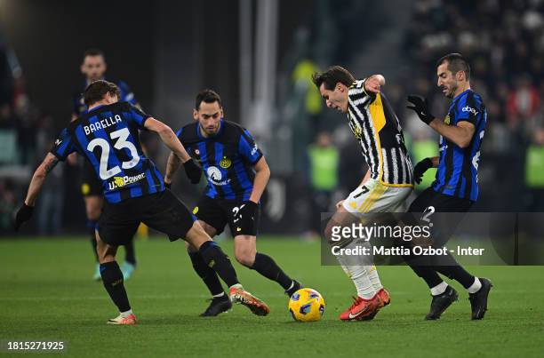 Nicolo Barella, Hakan Calhanoglu and Henrikh Mkhitaryan of FC Internazionale competes for the ball with Federico Chiesa of Juventus during the Serie...