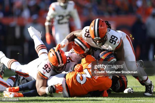 Russell Wilson of the Denver Broncos is tackled as he carries the ball for a first down in the first quarter of the game against the Cleveland Browns...