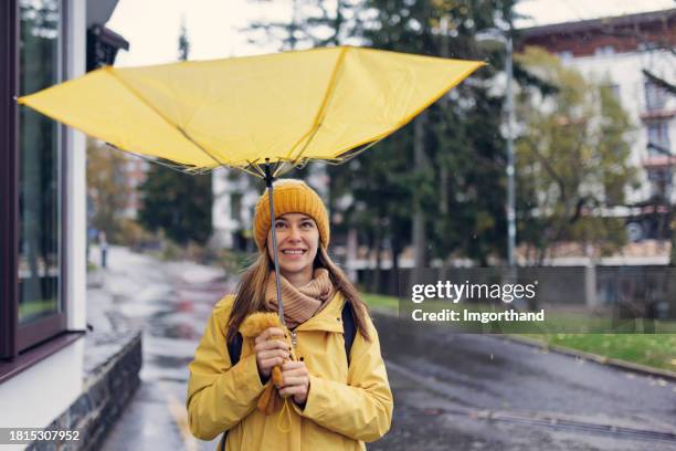 funny portrait of a teenage girl with umbrella flipped inside out by the wind - virada ao contrário imagens e fotografias de stock