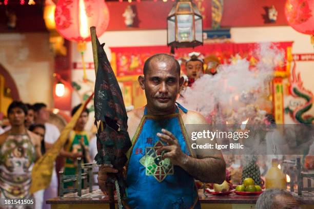 Devotees of the Chinese Kathu Shrine, go into a trance as they prepare themselfs to be pierced during a procession of the Vegetarian Festival, Phuket...