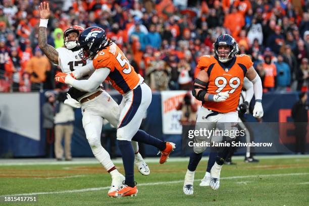 Baron Browning of the Denver Broncos hits Dorian Thompson-Robinson of the Cleveland Browns on a play in the third quarter of the game at Empower...