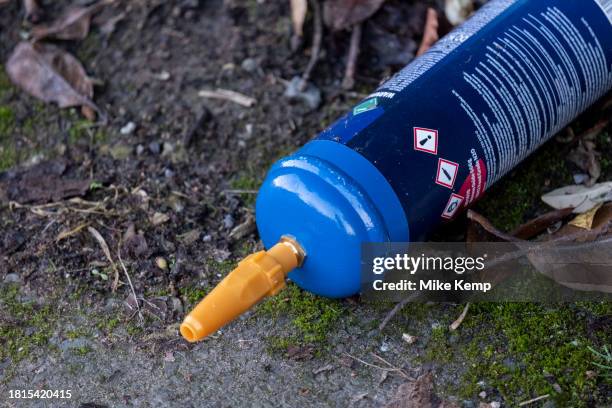 Empty large size gas cannister of nitrous oxide / laughing gas lying on the street on 1st December 2023 in Birmingham, United Kingdom. It has been...