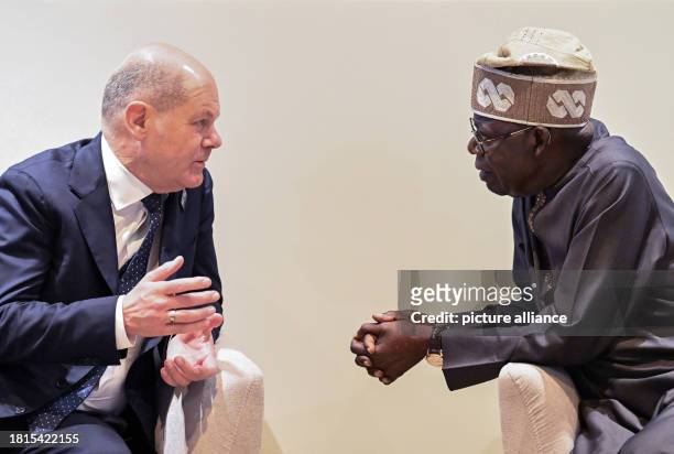 December 2023, United Arab Emirates, Dubai: Federal Chancellor Olaf Scholz and Bola Tinubu, President of Nigeria, talk in the Nigerian pavilion...