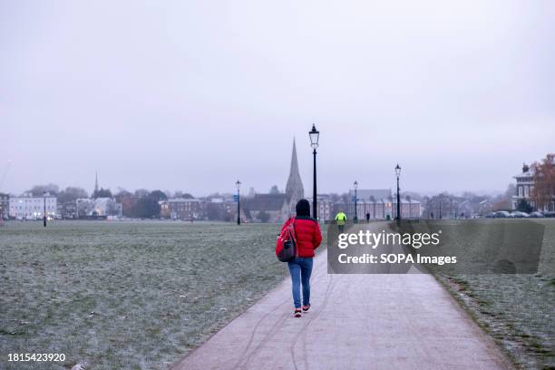 Person seen walking in the freezing early morning weather at Blackheath Park in London. Greenwich Park and Blackheath Park in South-east London are...
