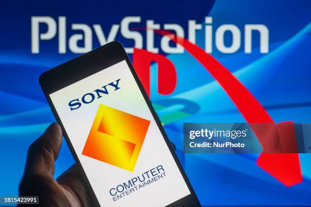 The Sony Interactive Entertainment logo is being displayed on a smartphone with a PlayStation and a stock graph visible in the background, in this...