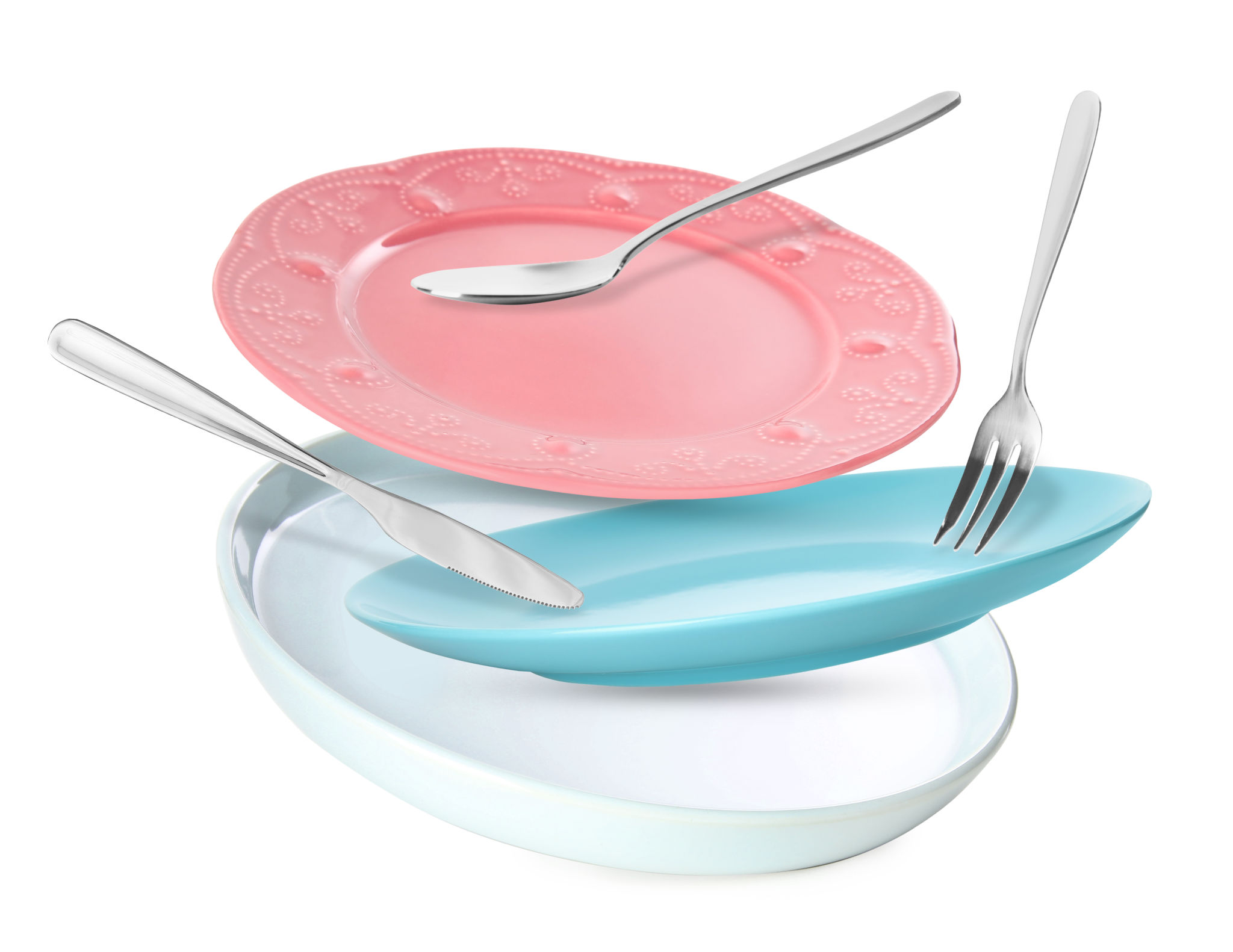 Clean plates, spoon, knife and fork falling on white background Clean plates, spoon, knife and fork falling on white background