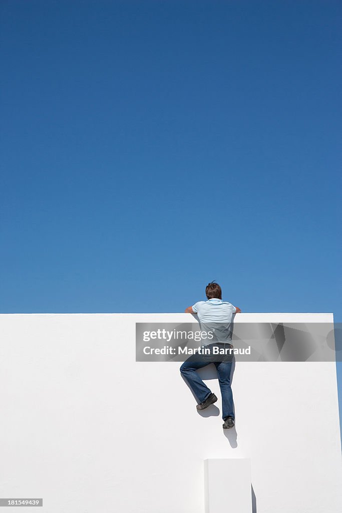 Homem na parede de escalada outdoor com céu azul