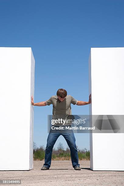 man standing between two walls outdoors pushing - pushing stock pictures, royalty-free photos & images