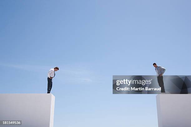 businessmen standing on wall looking down  - distante stock pictures, royalty-free photos & images