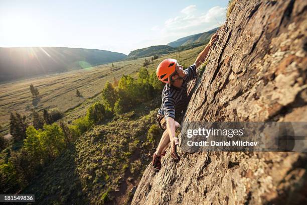 guy rock climbing at sunset. - varappe photos et images de collection