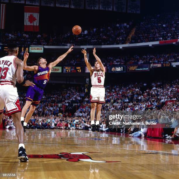 John Paxson of the Chicago Bulls takes a jumper against the Phoenix Suns during Game Four of the 1993 NBA Championship Finals at Chicago Stadium on...