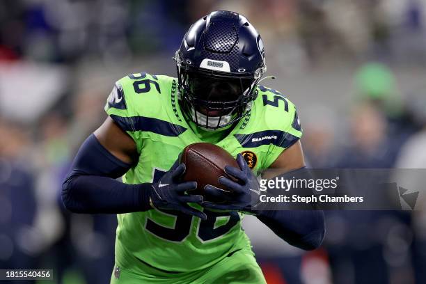 Jordyn Brooks of the Seattle Seahawks intercepts a pass from Brock Purdy of the San Francisco 49ers to score a touchdown during the third quarter at...
