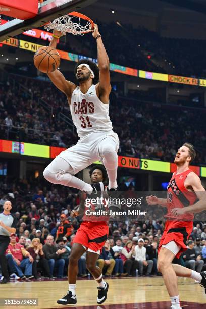 Jarrett Allen of the Cleveland Cavaliers dunks over Jakob Poeltl of the Toronto Raptors during the first quarter at Rocket Mortgage Fieldhouse on...