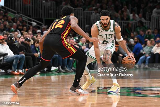 Jayson Tatum of the Boston Celtics dribbles against De'Andre Hunter of the Atlanta Hawks during the fourth quarter at the TD Garden on November 26,...
