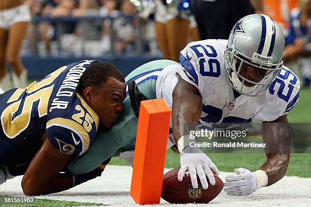 DeMarco Murray of the Dallas Cowboys scores a touchdown while tackled by T.J. McDonald of the St. Louis Rams at AT&T Stadium on September 22, 2013 in...