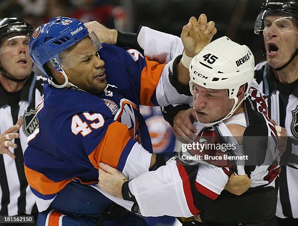 Justin Johnson of the New York Islanders fights with Cam Janssen of the New Jersey Devils during the third period in a preseason game at the Barclays...