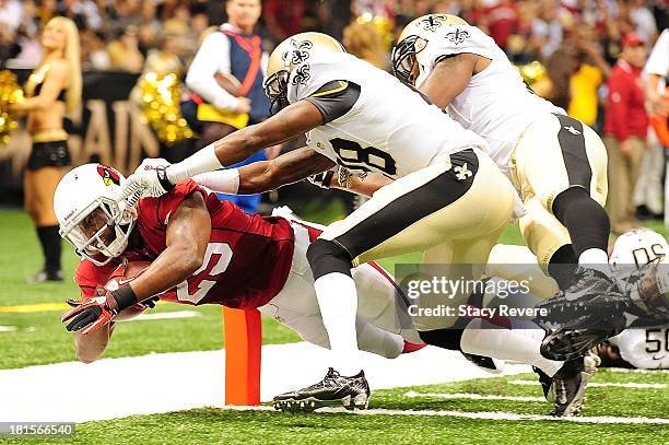 Alfonso Smith of the Arizona Cardinals dives for a touchdown in front of Rod Sweeting of the New Orleans Saints during a game at the Mercedes-Benz...