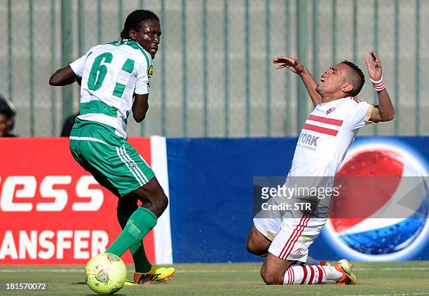 Zamalek's Hazem Emam falls to the ground as AC Leopards' player Dimitri Magnoleke Bissiki watches on during their AFC Champions League Group A...