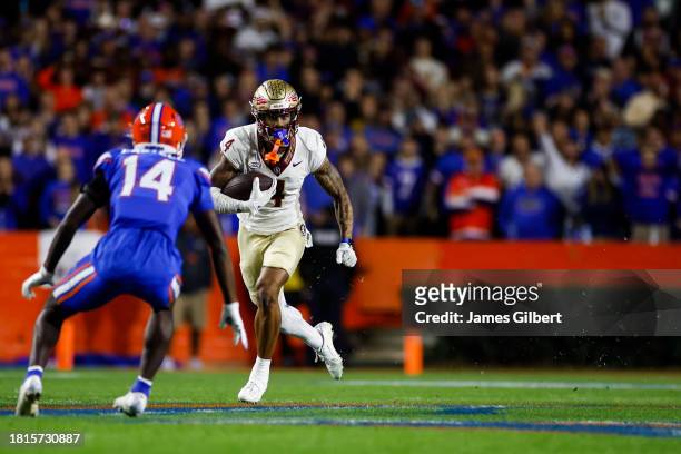 Keon Coleman of the Florida State Seminoles runs with the ball after making a catch during the second half of a game against the Florida Gators at...
