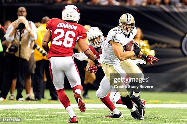 Rashad Johnson of the Arizona Cardinals prepares to tackle Jimmy Graham of the New Orleans Saints during a game at the Mercedes-Benz Superdome on...