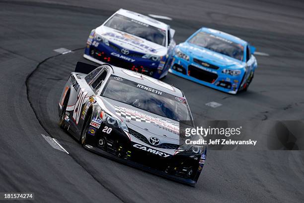 Matt Kenseth, driver of the Home Depot / Husky Toyota, leads Brian Vickers, driver of the Aaron's Dream Machine Toyota, and Jamie McMurray, driver of...