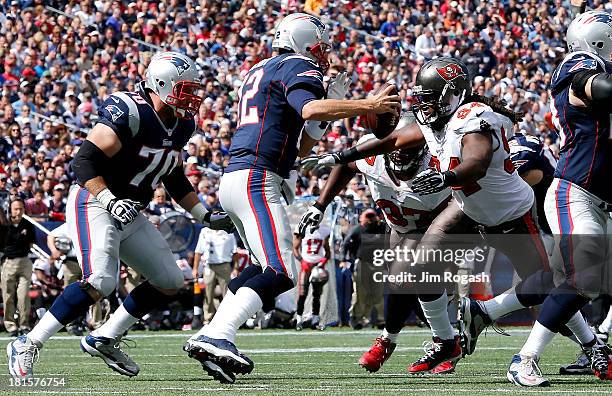 Tom Crabtree of the Tampa Bay Buccaneers chases Tom Brady of the New England Patriots reacts during the first half at Gillette Stadium on September...