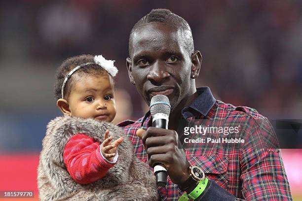 Football player Mamadou Sakho of Liverpool delivers a speech to the fans of his former Paris Saint Germain, as he carries his young daughter during...