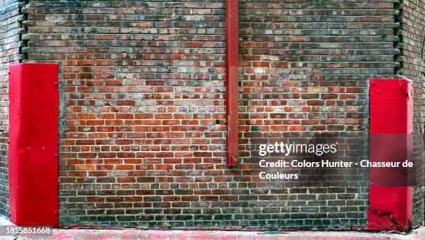 corner wall of weathered brick and cement with red painted metal plates in montreal, quebec, canada - 角 ストックフォトと画像