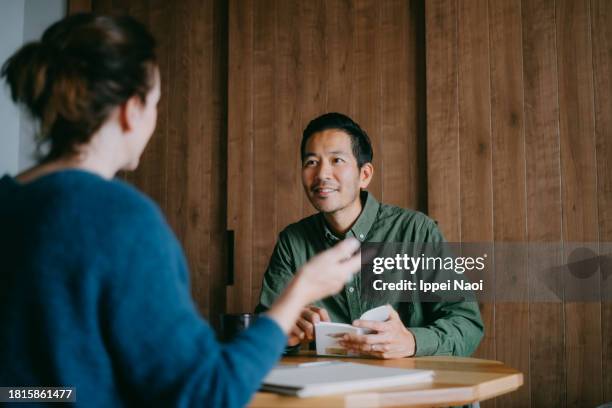 man and woman in small business meeting - entrevista imagens e fotografias de stock