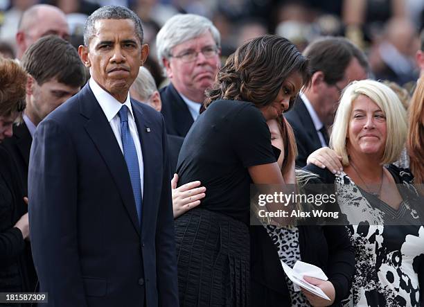 President Barack Obama pauses as first lady Michelle Obama hugs a family membr during a memorial service for victims of the Washington Navy Yard...