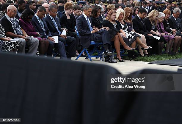 President Barack Obama and first lady Michelle Obama join a prayer as they attend a memorial service for victims of the Washington Navy Yard shooting...