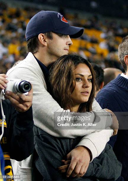 Ashton Kutcher and Mila Kunis look on from the sidelines before the game between the Chicago Bears and the Pittsburgh Steelers on September 22, 2013...