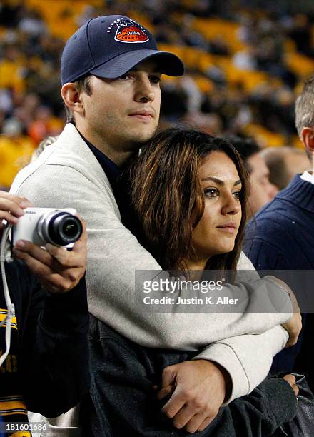 Ashton Kutcher and Mila Kunis look on from the sidelines before the game between the Chicago Bears and the Pittsburgh Steelers on September 22, 2013...