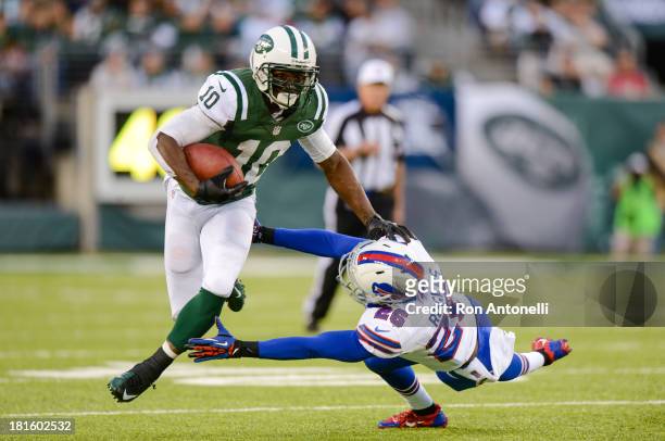 Wide receiver Santonio Holmes of the New York Jets stiff arms defensive back Justin Rogers of the Buffalo Bills as he runs after a catch in the 2nd...