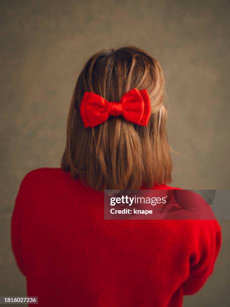 frau in rotem pullover und roter haarschleifenfrisur - hair bow stock-fotos und bilder