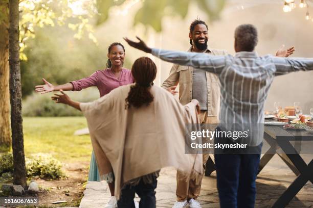 happy black couple greeting senior couple in the backyard. - son in law stock pictures, royalty-free photos & images