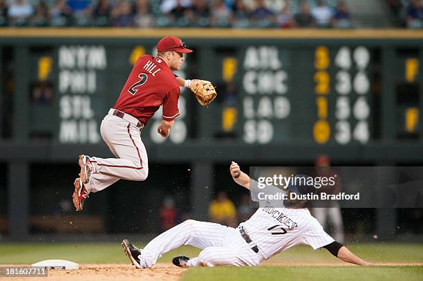 Aaron Hill of the Arizona Diamondbacks leaps on a double play attempt after forcing out the sliding Todd Helton of the Colorado Rockies in the ninth...
