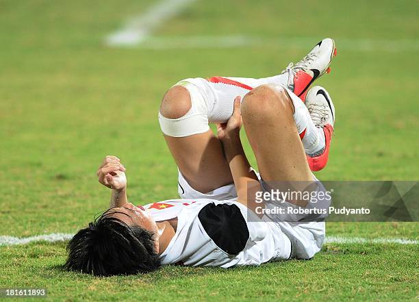 Nguyen Tuan Anh of Vietnam falls to the ground after being hit by a sliding tackle during the AFF U19 Cup Final match between Indonesia and Vietnam...