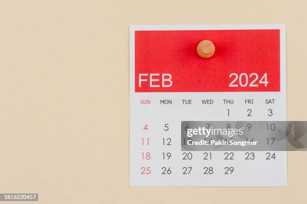 desk calendar 2024: february calendar is used to plan daily work and life with a push pin on a beige color paper background. - febrero fotografías e imágenes de stock