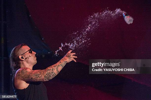 Shadows of American heavy metal band Avenged Sevenfold throws a cup of water to fans during the final day of the Rock in Rio music festival in Rio de...