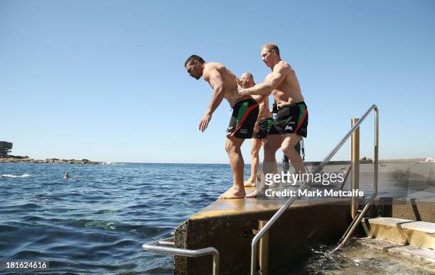 Michael Crocker holds Ben Te'o during a South Sydney Rabbitohs NRL recovery session at Clovelly Beach on September 23, 2013 in Sydney, Australia.