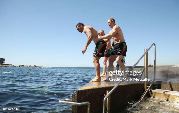 Michael Crocker holds Ben Te'o during a South Sydney Rabbitohs NRL recovery session at Clovelly Beach on September 23, 2013 in Sydney, Australia.