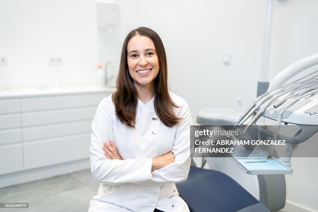 Dentist smiling at camera sitting on a dental clinic