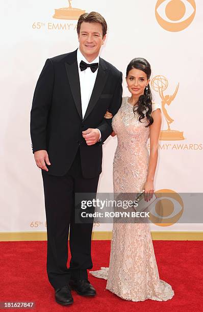 Actor Nathan Fillion and actress Mikaela Hoover arrive on the red carpet for the 65th Emmy Awards in Los Angeles, California, on September 22, 2013....