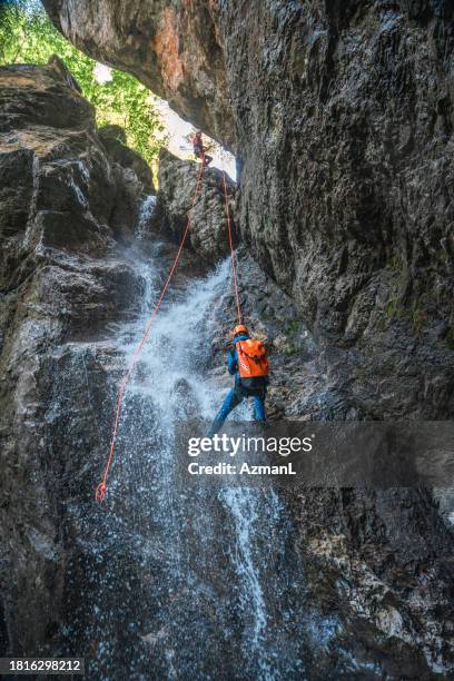 person rappelling down soča river waterfall - slovenia spring stock pictures, royalty-free photos & images